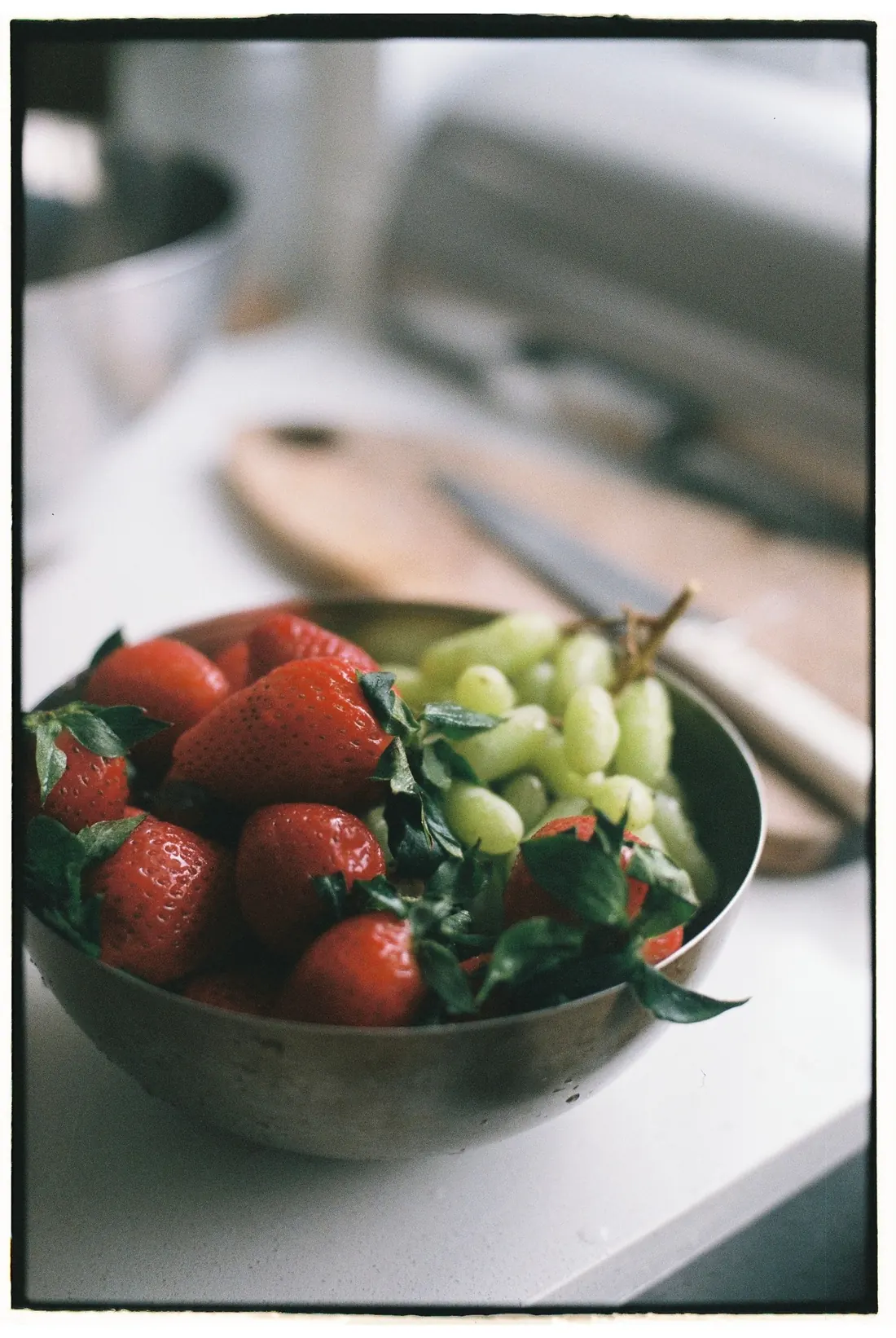 Bowl de morangos e uvas sobre a bancada